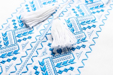 Beautiful light blue Ukrainian national embroidery on white fabric, closeup