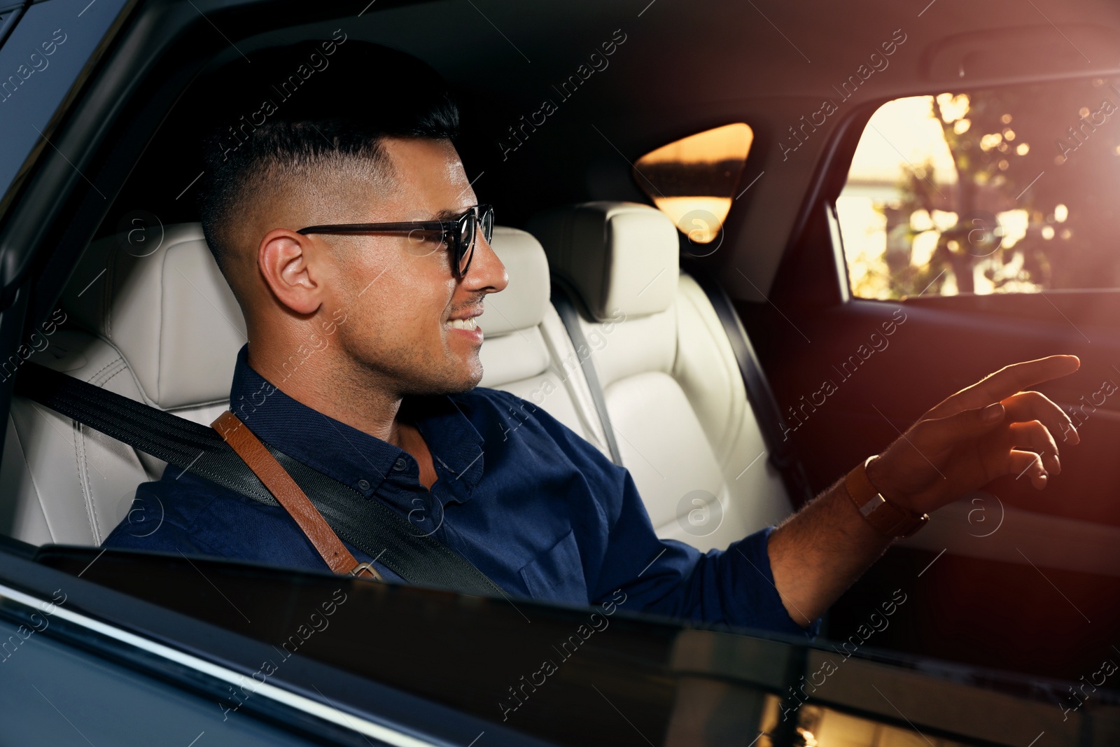 Photo of Businessman sitting on backseat of modern taxi