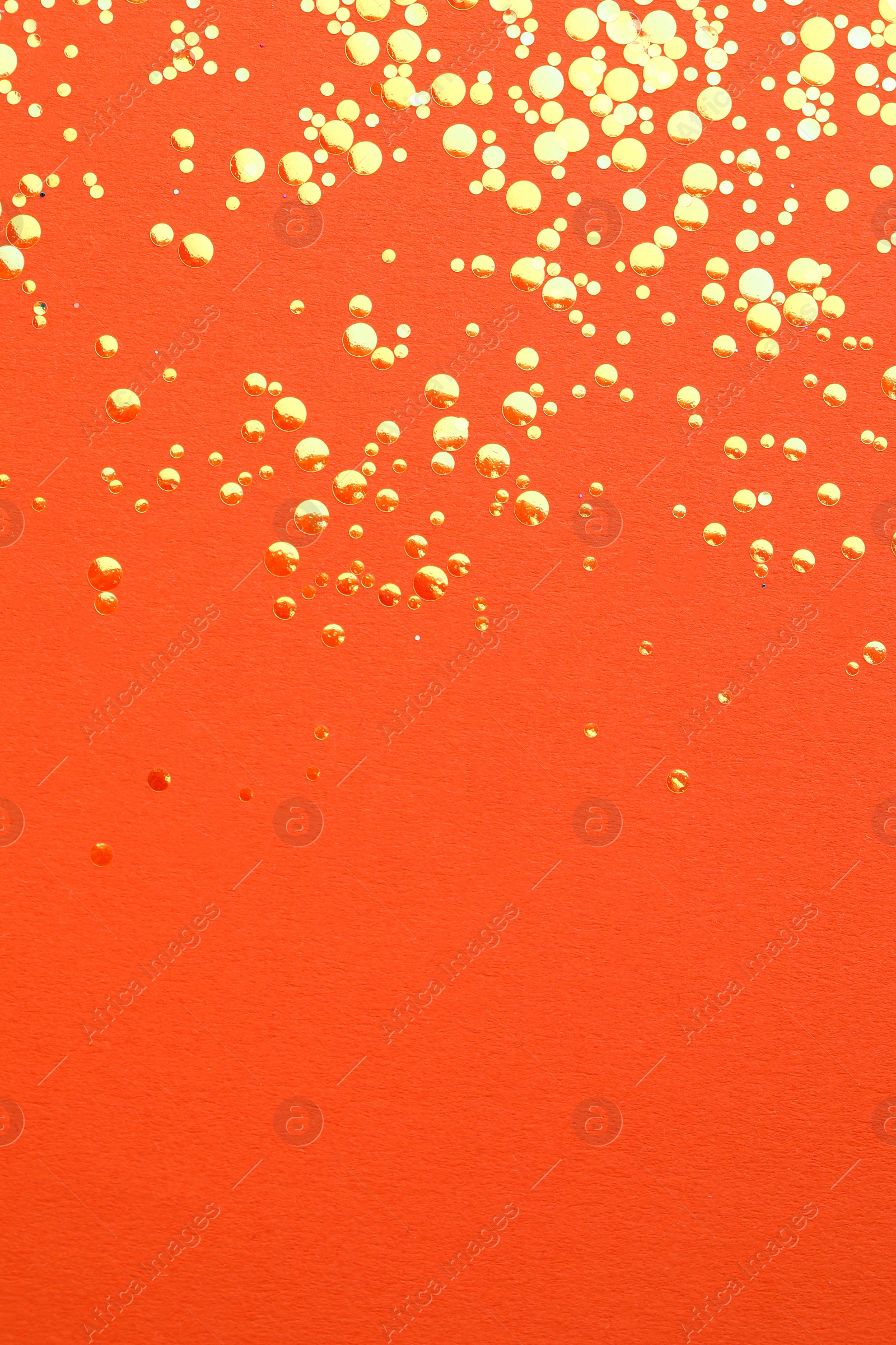 Photo of Shiny bright golden glitter on orange background, flat lay. Space for text