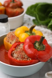 Photo of Delicious stuffed bell peppers on white table, closeup