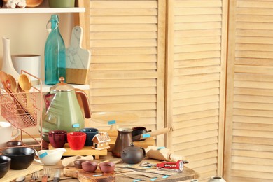 Many different cooking utensils in room, space for text. Garage sale