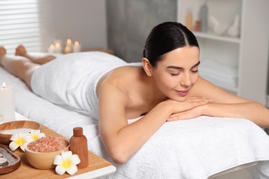 Beautiful woman relaxing on massage table in spa salon