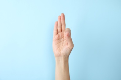Photo of Woman showing F letter on color background, closeup. Sign language