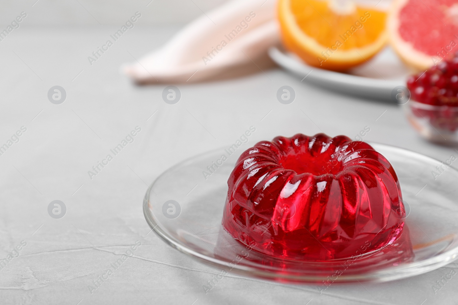 Photo of Delicious fresh red jelly on grey table, space for text