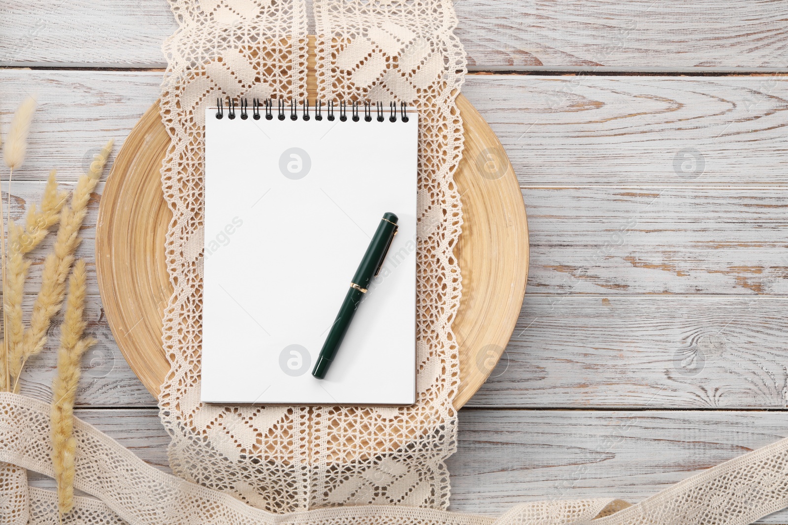 Photo of Guest list. Notebook, pen, spikelets and lace ribbons on wooden background, flat lay. Space for text