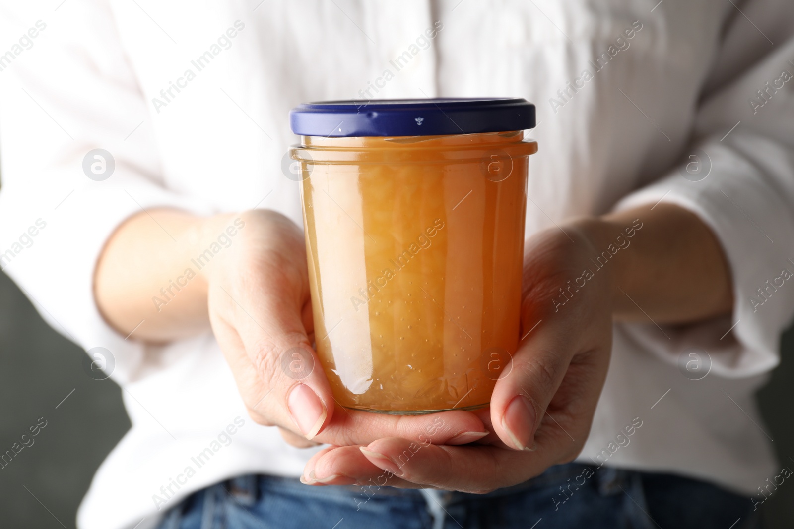 Photo of Woman with jar of delicious jam, closeup