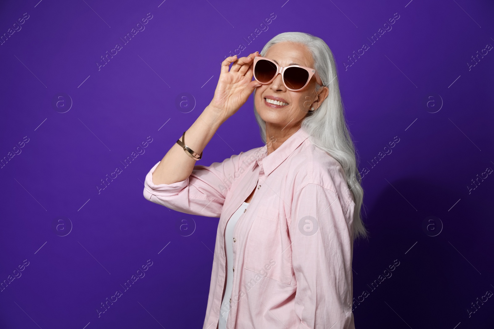 Photo of Portrait of beautiful mature woman on violet background