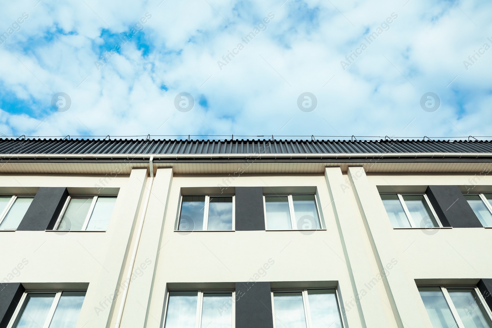 Photo of Exterior of white apartment building on cloudy day, low angle view