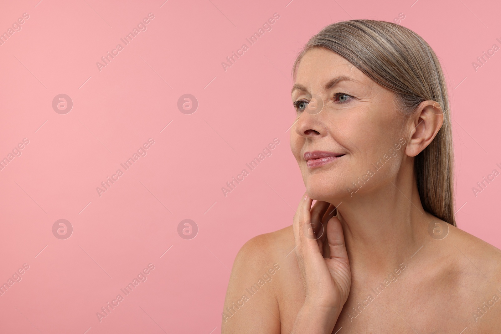 Photo of Beautiful woman touching her neck on pink background, space for text