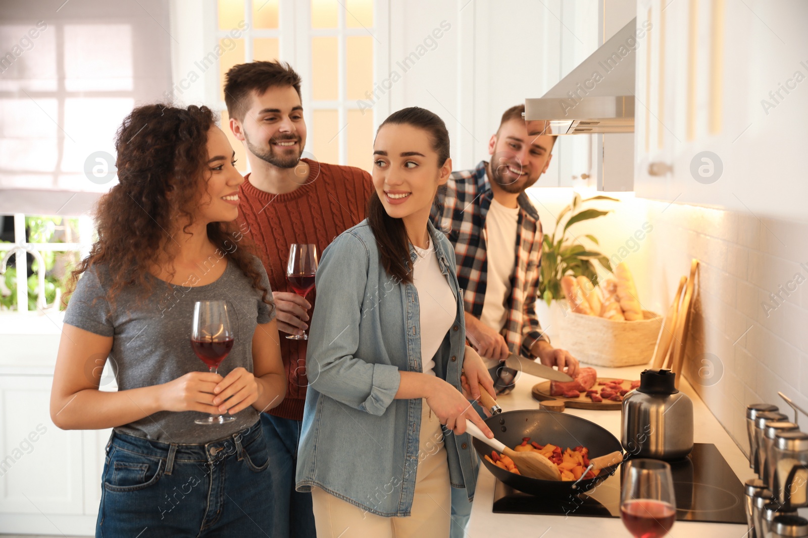 Photo of Happy people cooking food together in kitchen