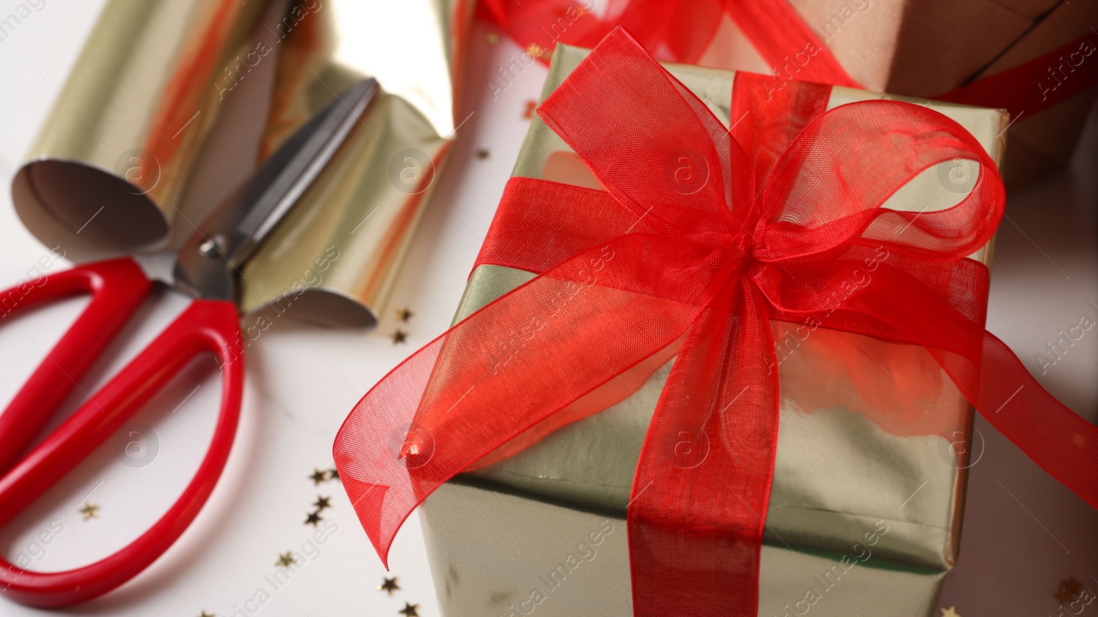 Photo of Beautifully wrapped gift box on white table, closeup