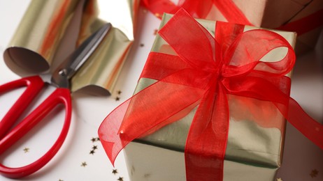 Photo of Beautifully wrapped gift box on white table, closeup