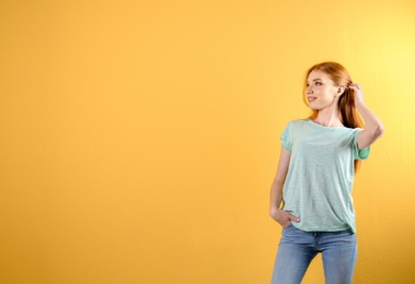 Photo of Young woman in stylish jeans on color background