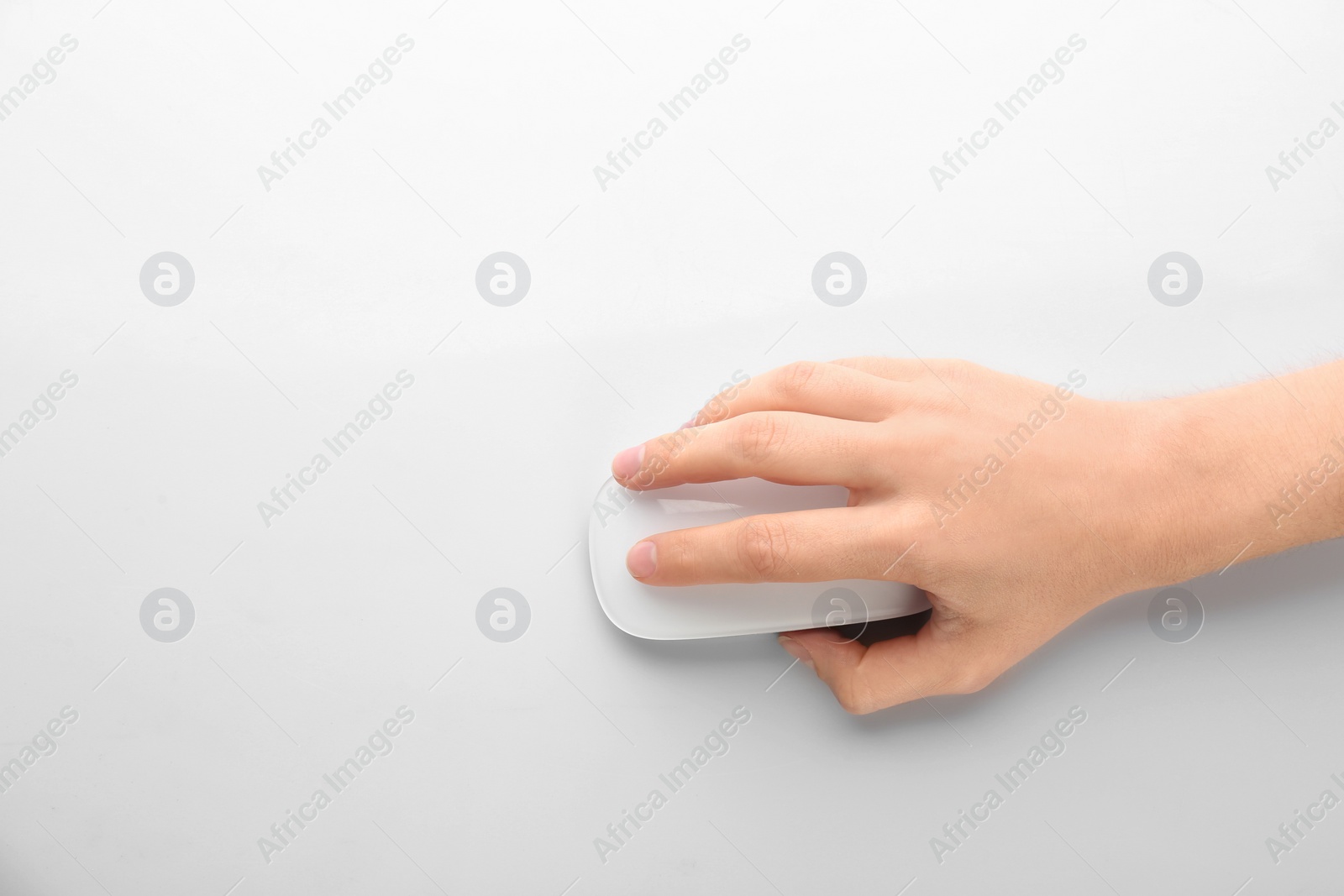 Photo of Woman using computer mouse on white background, top view. Space for text