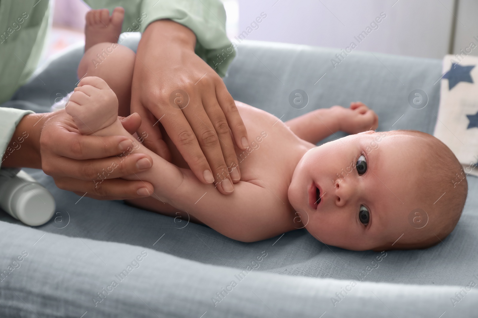 Photo of Mother taking care of her baby on changing table indoors, closeup