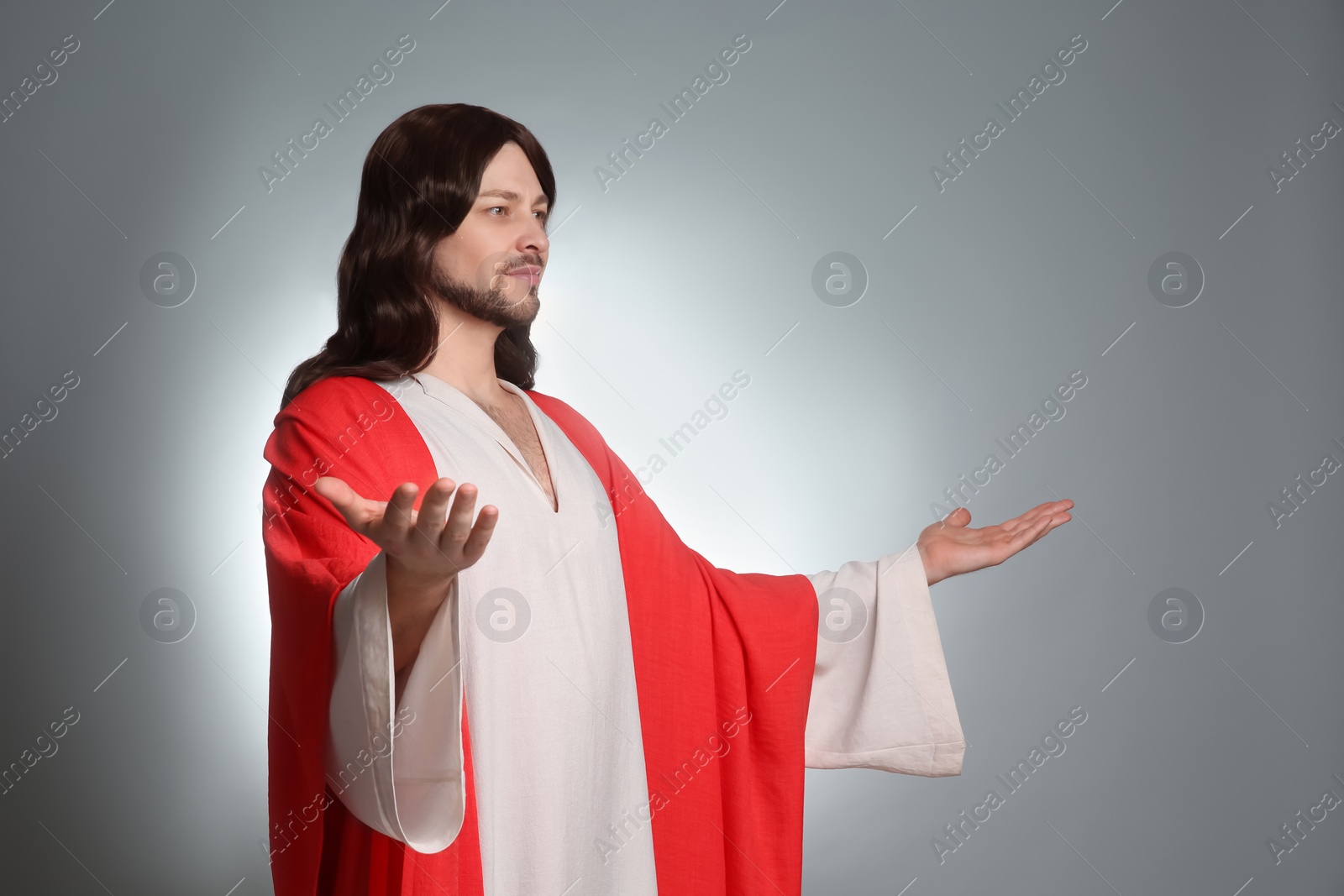 Photo of Jesus Christ with outstretched arms on light grey background