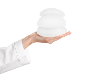 Doctor holding silicone implants for breast augmentation on white background. Cosmetic surgery