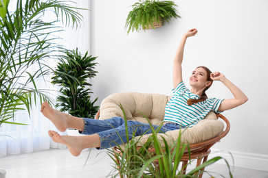 Young woman in room decorated with plants. Home design