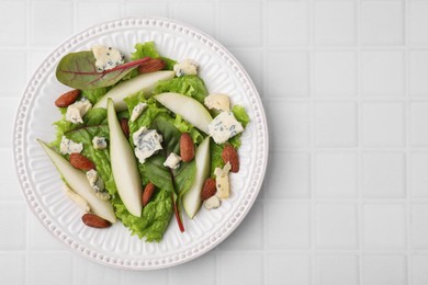 Photo of Delicious pear salad on white tiled table, top view. Space for text