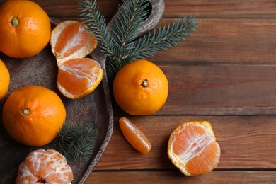 Photo of Tray with delicious ripe tangerines and fir branches on wooden table, flat lay. Space for text