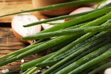 Photo of Fresh green onion on wooden table, closeup