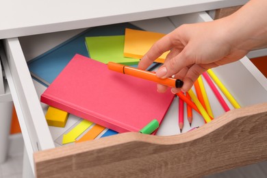 Photo of Woman putting marker into desk drawer, closeup