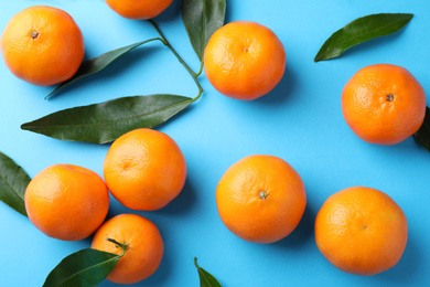 Fresh ripe tangerines on light blue background, flat lay