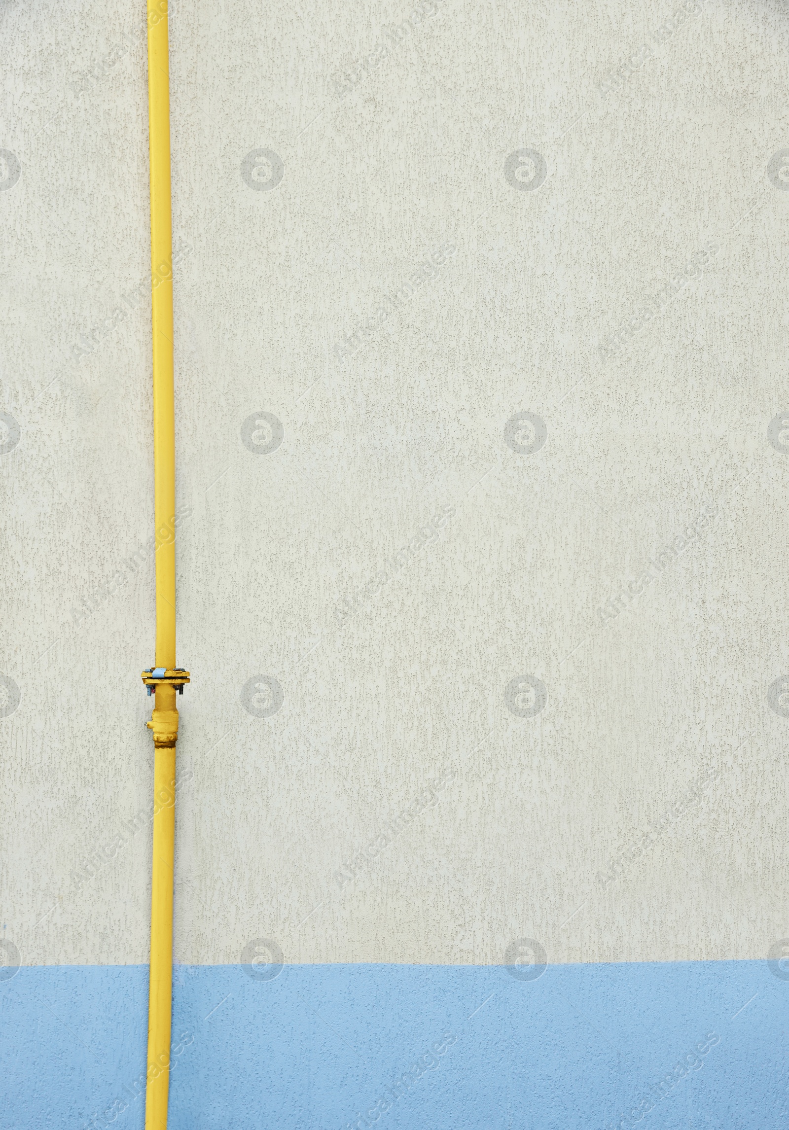 Photo of Yellow gas pipe near beige wall outdoors, space for text