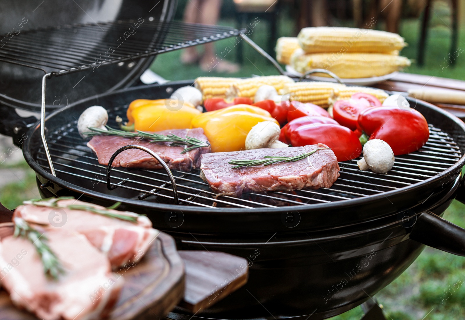 Photo of Barbecue grill with meat and vegetables outdoors, closeup