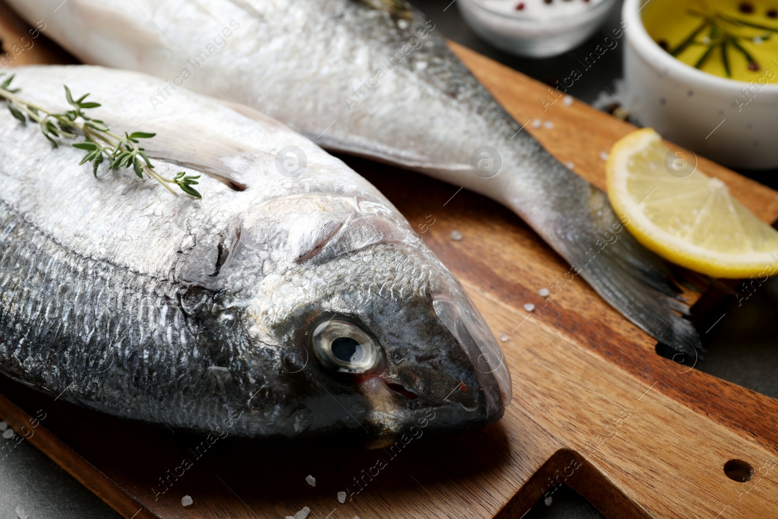 Photo of Fresh dorado fish and ingredients on wooden board, closeup