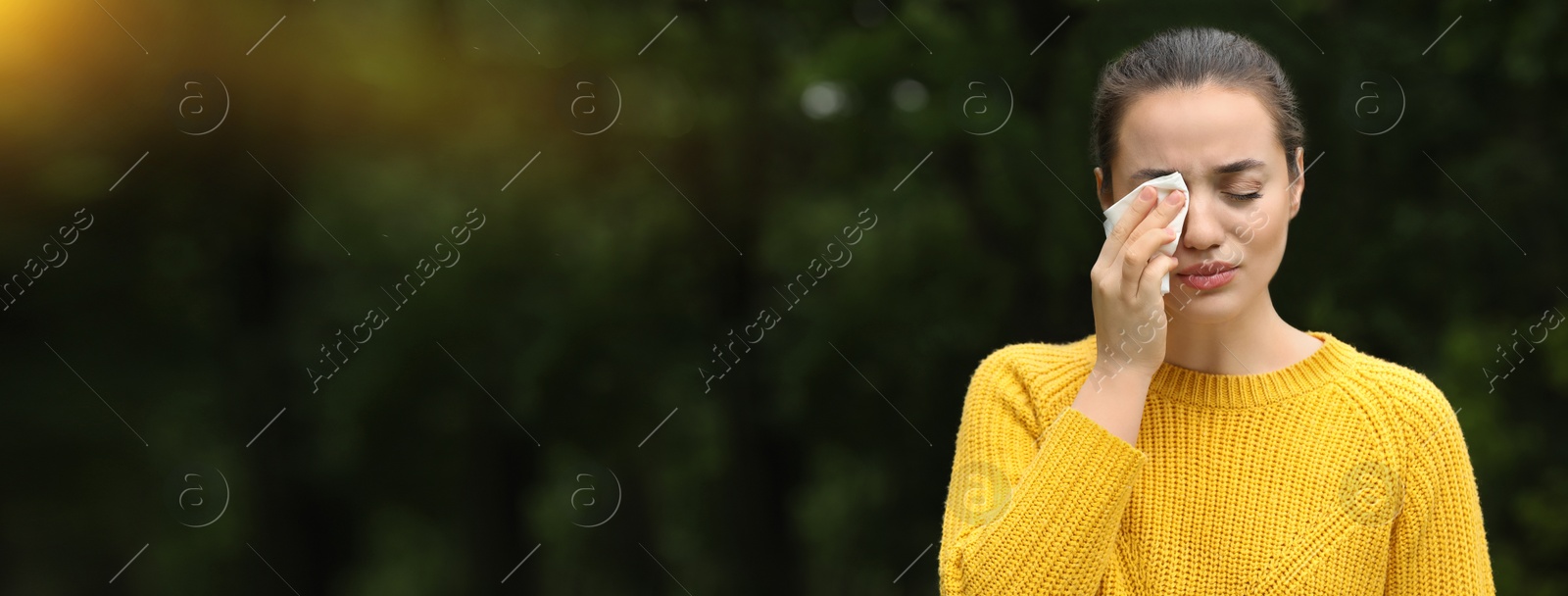 Image of Woman suffering from seasonal spring allergy outdoors. Banner design with space for text