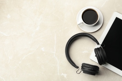 Photo of Flat lay composition with headphones, tablet and cup of coffee on table. Space for text