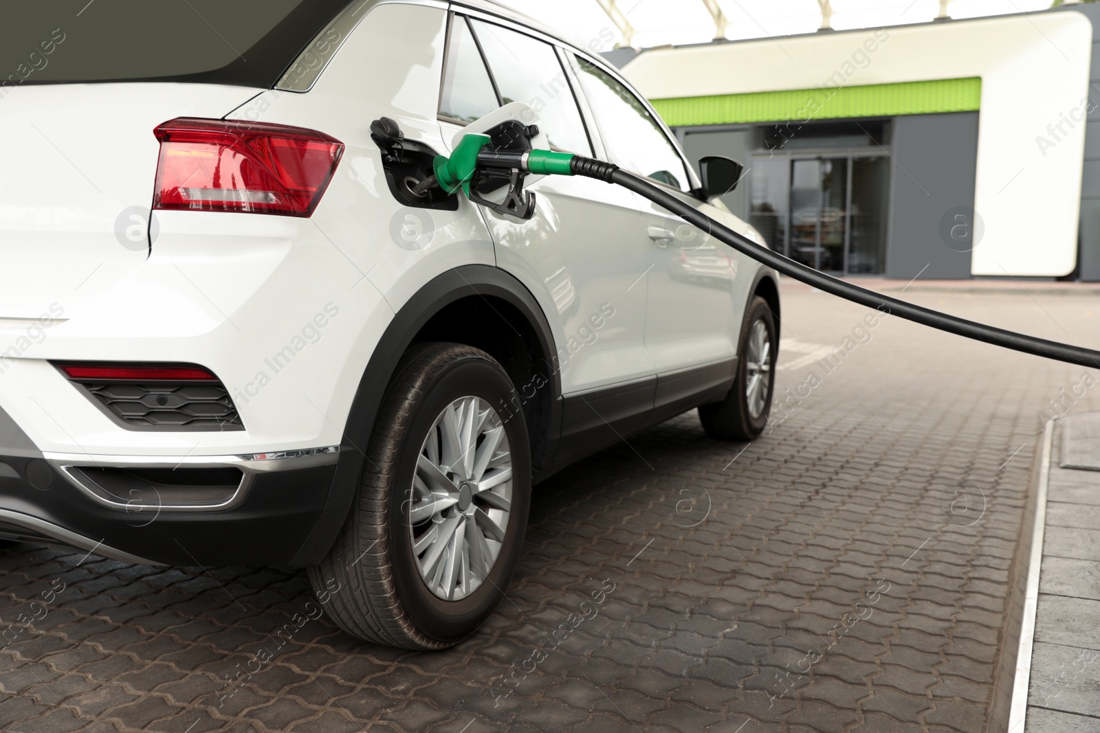 Photo of Refueling modern car at gas filling station, closeup