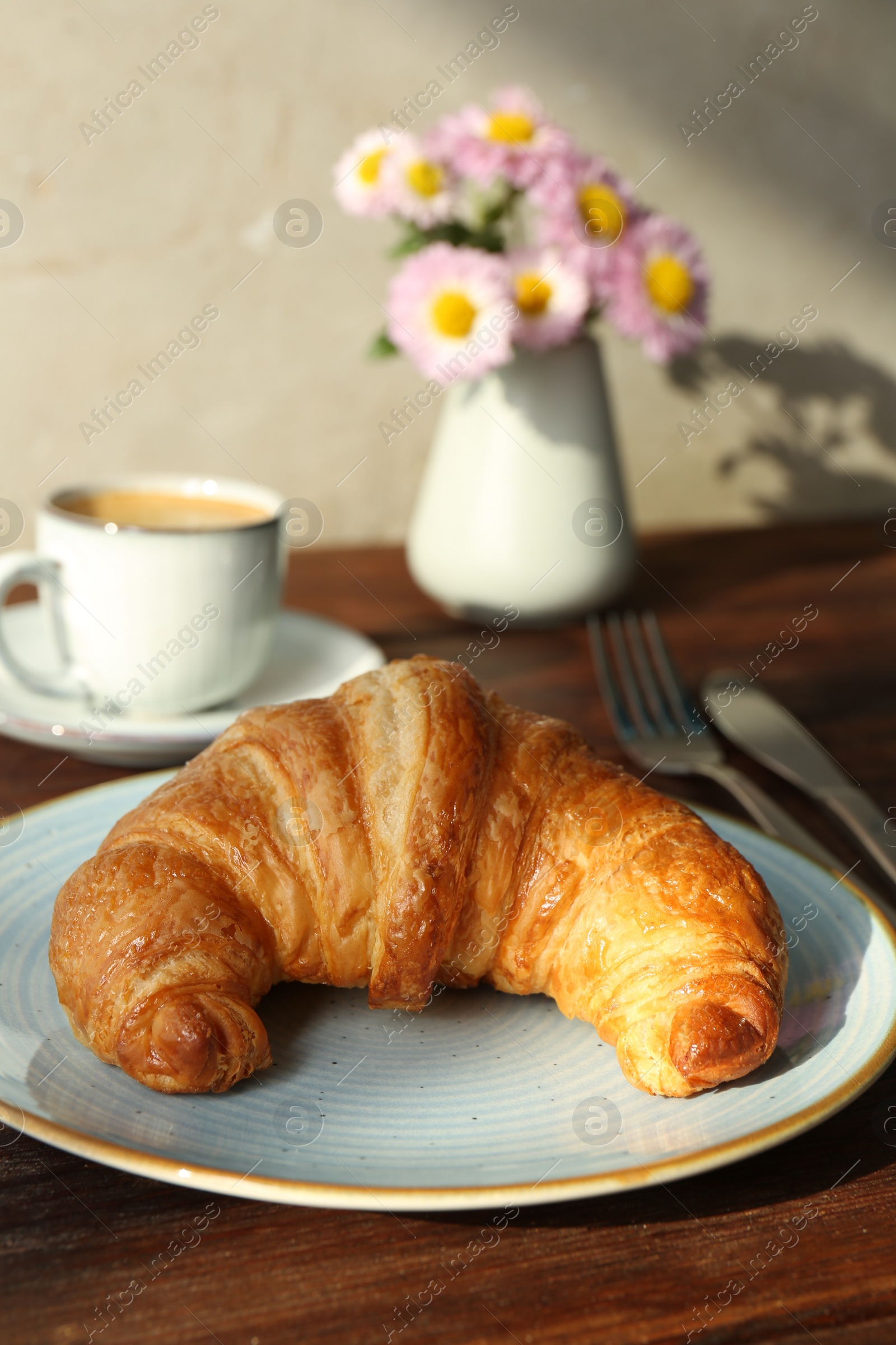 Photo of Delicious fresh croissant served with coffee on wooden table