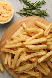 Delicious french fries served with sauce on light grey marble table, flat lay