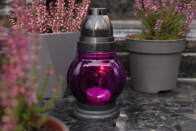 Photo of Grave lantern on grey granite surface at cemetery