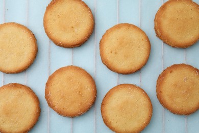 Photo of Tasty sweet sugar cookies on light blue background, top view