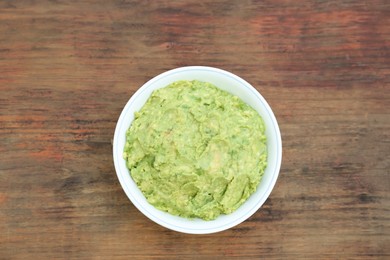 Delicious guacamole made of avocados on wooden table, top view