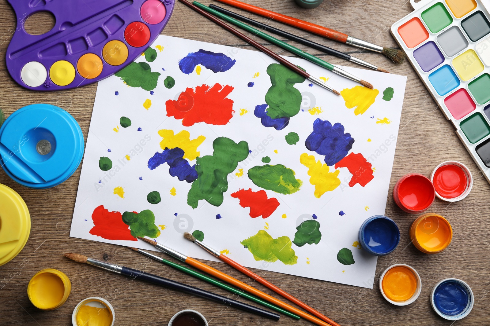 Photo of Flat lay composition with abstract child's painting on wooden table