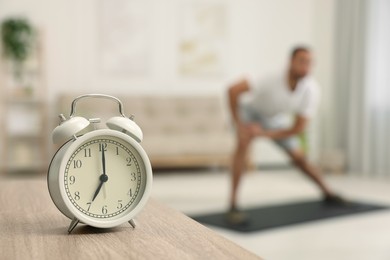 Photo of Man doing morning exercise on fitness mat at home, selective focus. Space for text