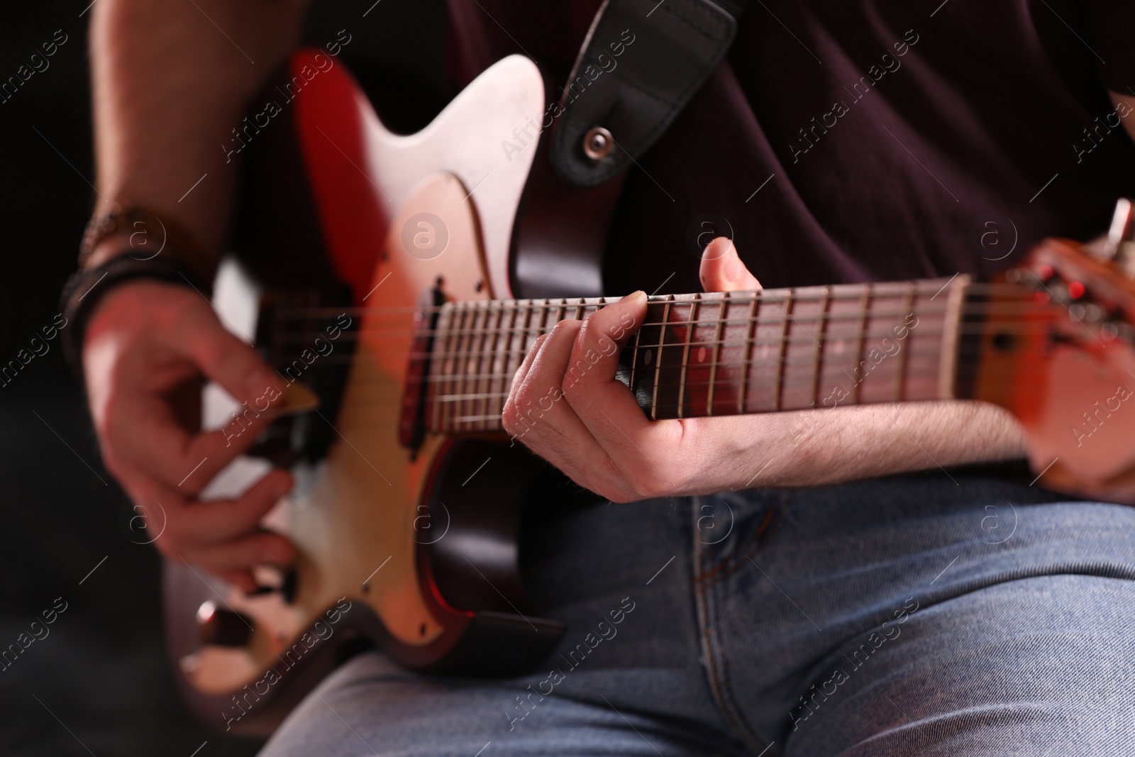 Photo of Man playing electric guitar on stage, closeup. Rock concert