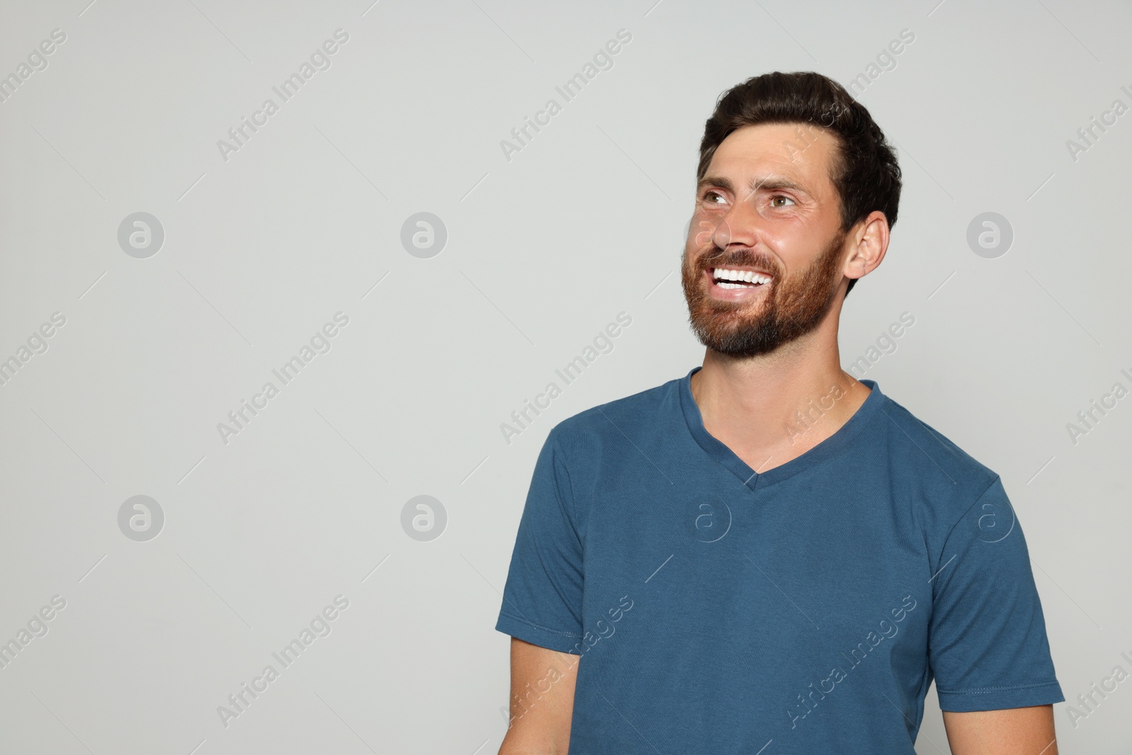 Photo of Portrait of happy bearded man on grey background. Space for text