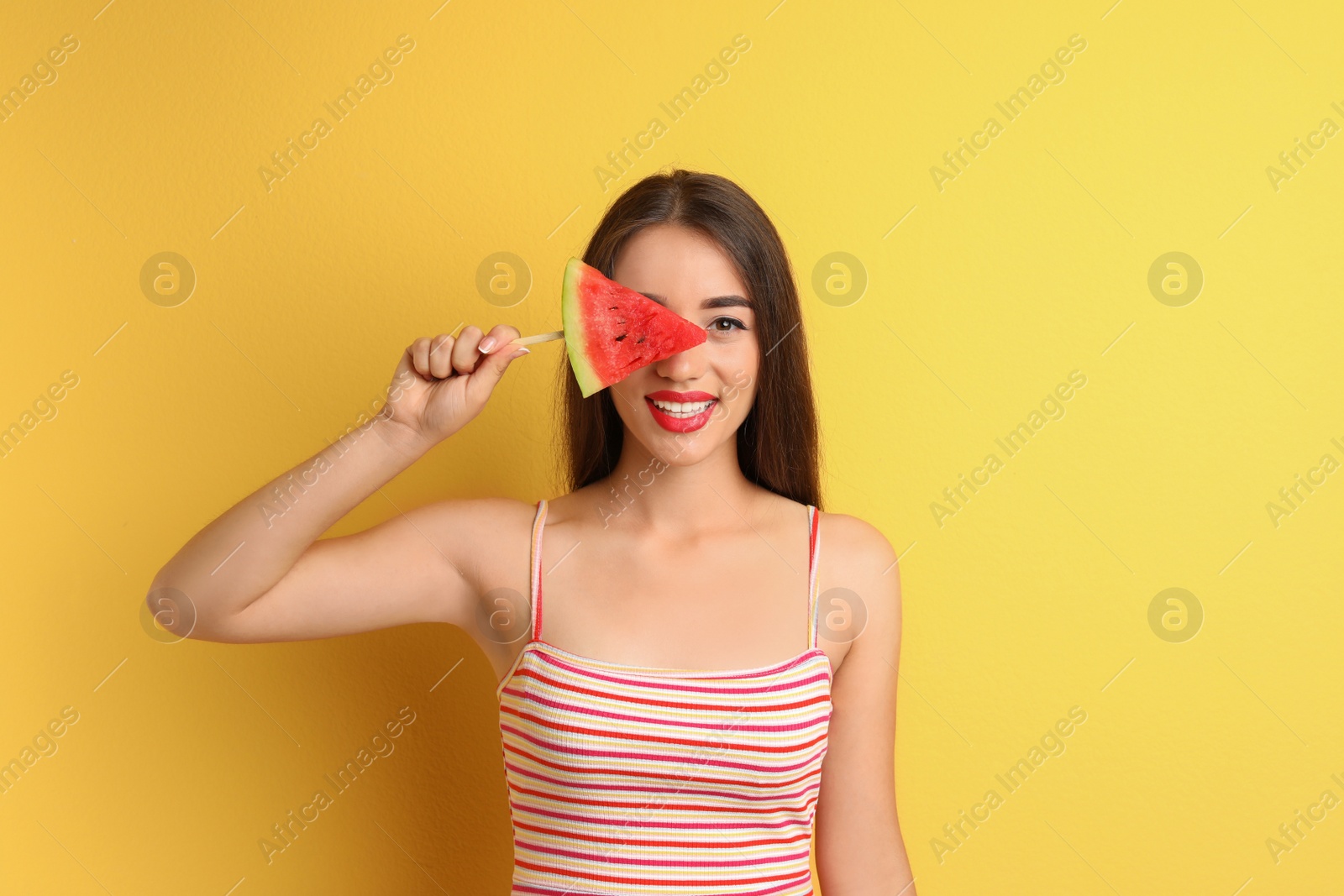 Photo of Beautiful young woman posing with watermelon on color background