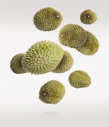 Image of Whole ripe durians falling on white background