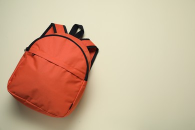 Photo of Stylish orange backpack on light background, top view. Space for text
