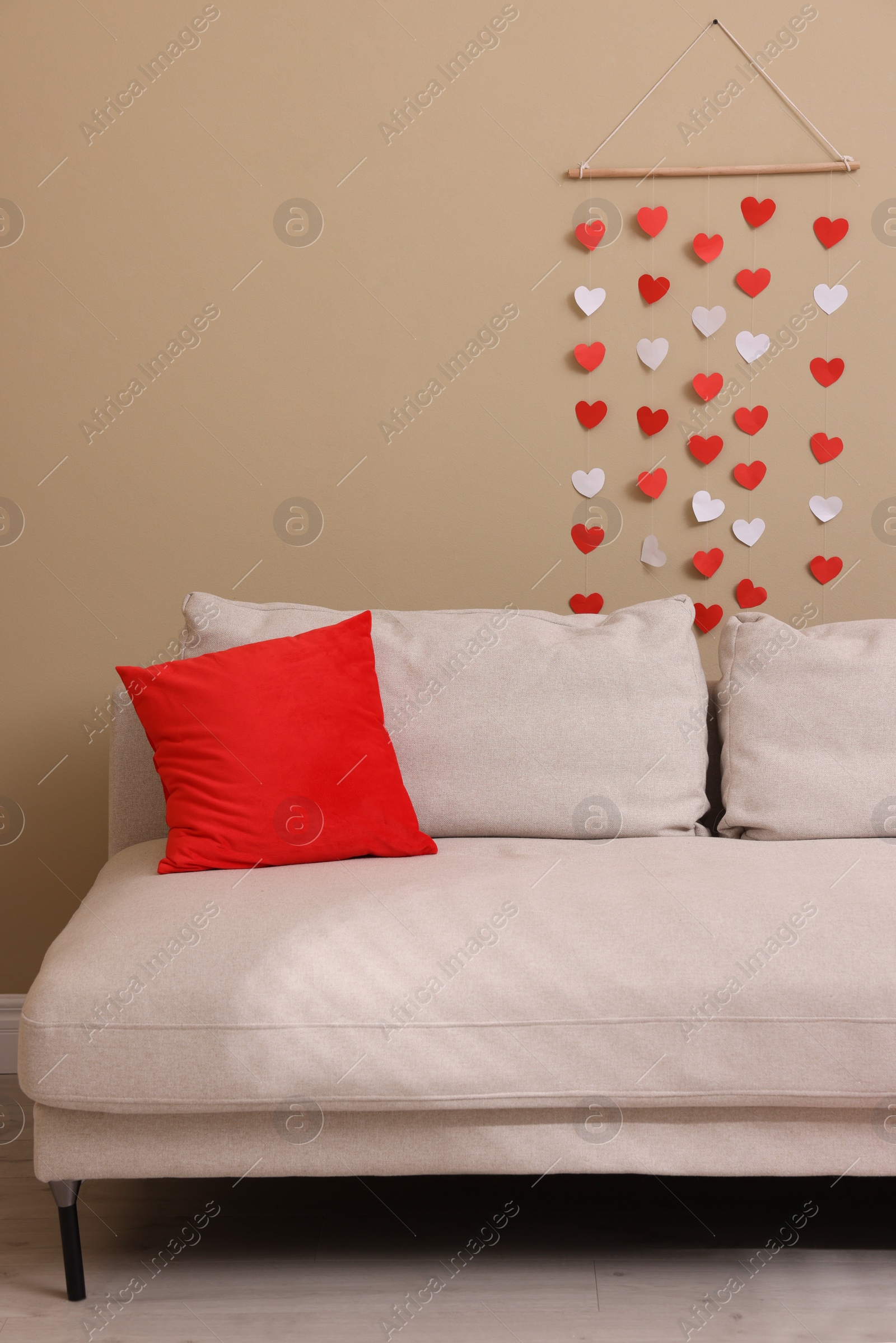 Photo of Cozy living room decorated for Valentine's Day with paper hearts. Interior design