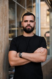 Portrait of handsome bearded man near building outdoors