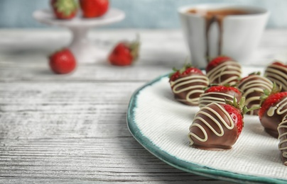 Photo of Plate with chocolate covered strawberries on table, closeup