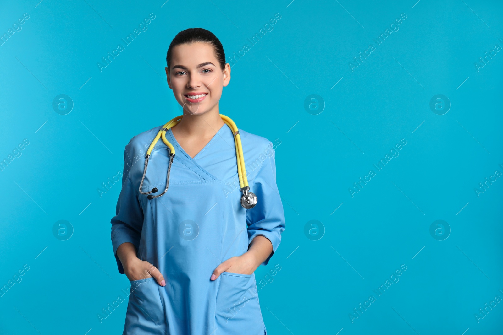 Photo of Portrait of young medical assistant with stethoscope on color background. Space for text