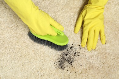 Photo of Woman removing stain from beige carpet, top view